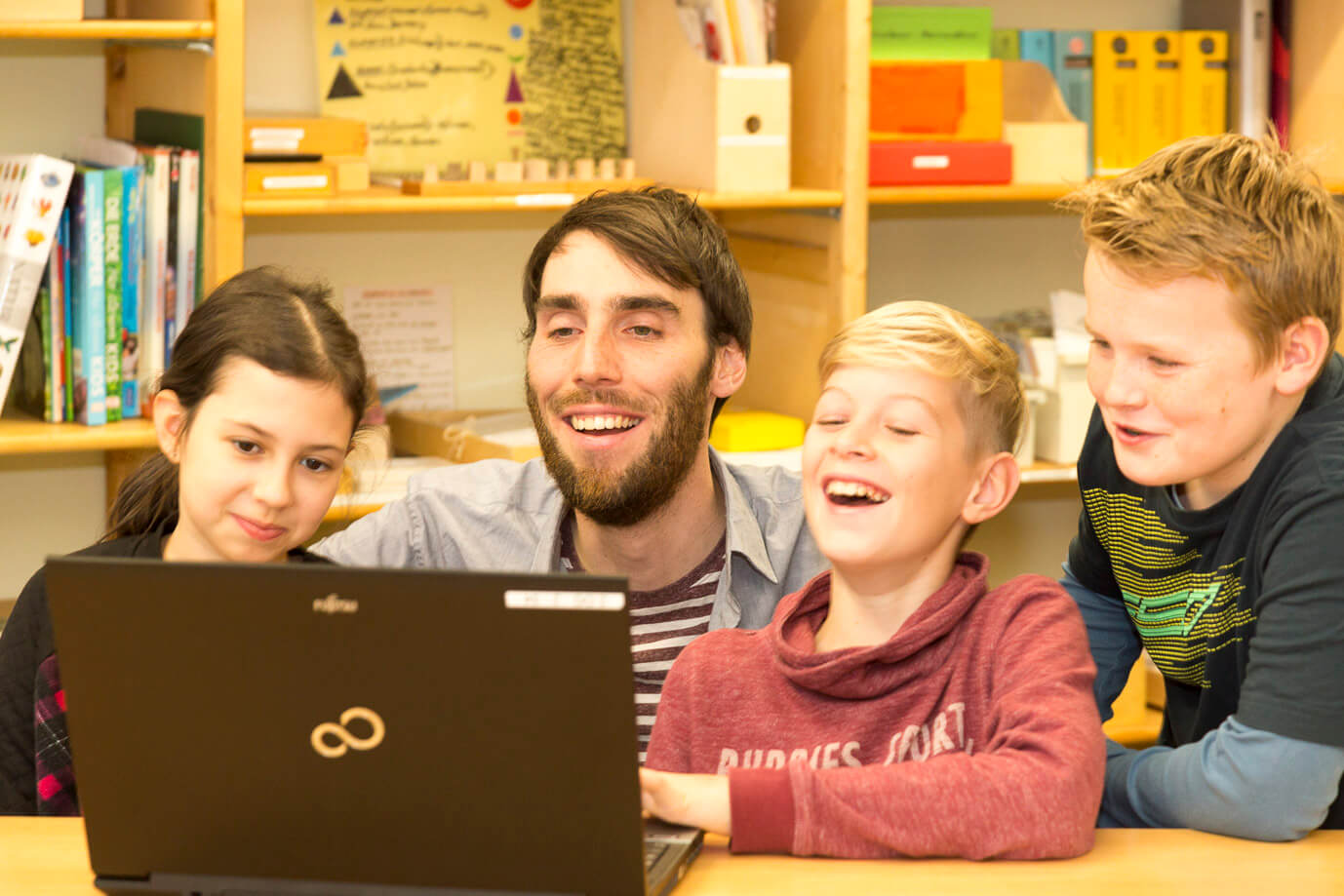 Mehrere Schüler mit Lehrer am Laptop Mehrere Schüler mit Lehrer am Laptop