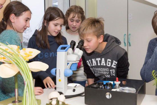 Schüler arbeiten an einem Mikroskop